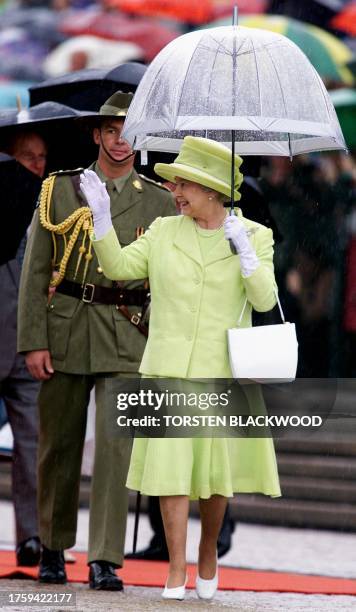 Britain's Queen Elizabeth II waves to admirers during an official welcoming ceremony in front of the Sydney Opera House 20 March 2000. The British...