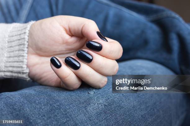 hand with dark blue glittered gel fingernails - esmalte de uñas negro fotografías e imágenes de stock