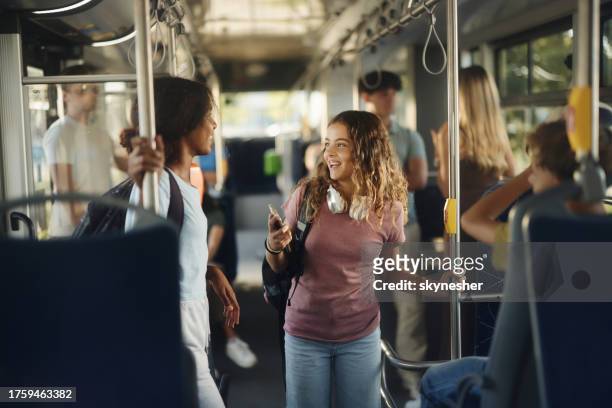 des élèves heureux qui parlent en se rendant à l’école en bus. - school bus stock photos et images de collection