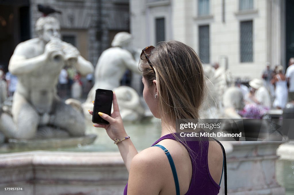 Young lady being playful with Roman statue