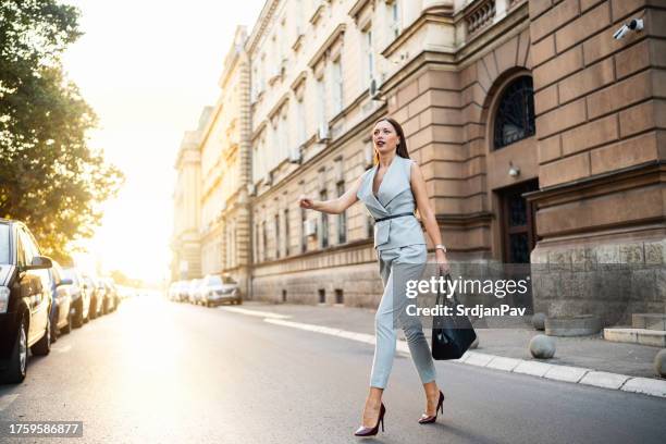 businesswoman crossing the city street - leather suit stock pictures, royalty-free photos & images