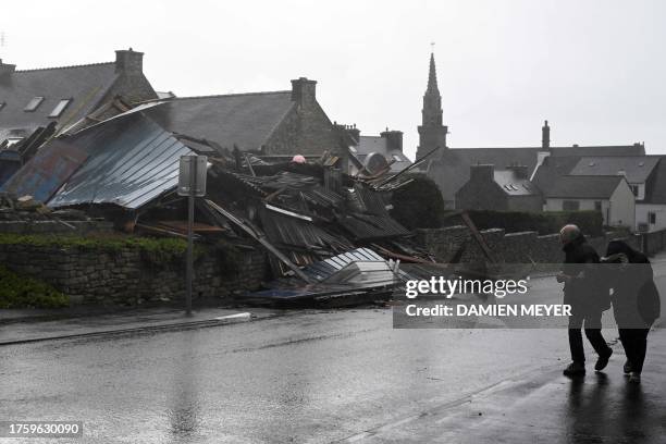 Pedestrians walk past a destroyed warehouse in Porspoder, western France, on November 2 as the storm Ciaran hits the region. Much of northwestern...