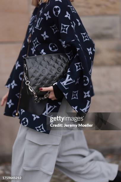 Sonia Lyson seen wearing Louis Vuitton black logo print pattern zip jacket with wide sleeves, Louis Vuitton black logo pattern leather clutch bag...