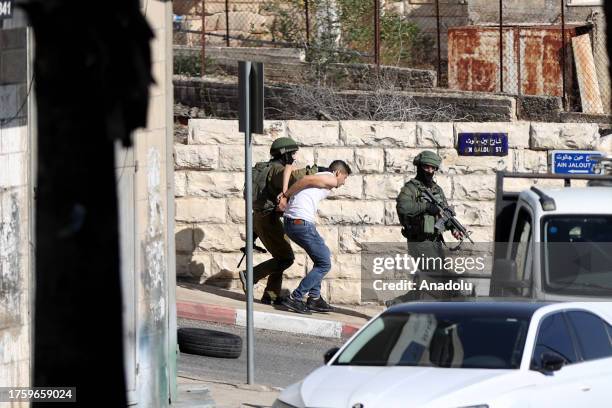 Israeli forces raid in streets and take a Palestinian into custody in Al-Bireh, West Bank on November 02, 2023.