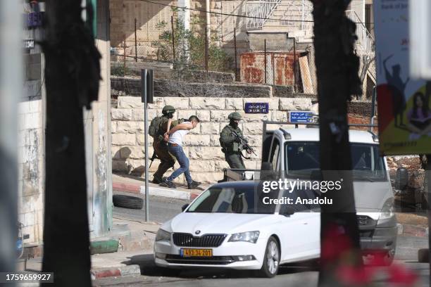 Israeli forces raid in streets and take a Palestinian into custody in Al-Bireh, West Bank on November 02, 2023.