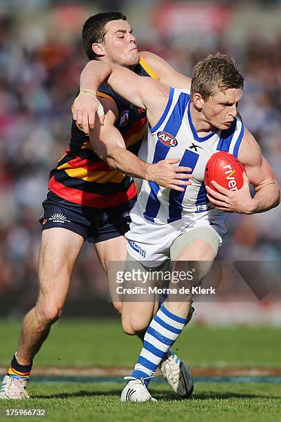 Brad Crouch of The Crows tackles Jack Ziebell of The Kangaroos during the round 20 AFL match between the Adelaide Crows and the North Melbourne...