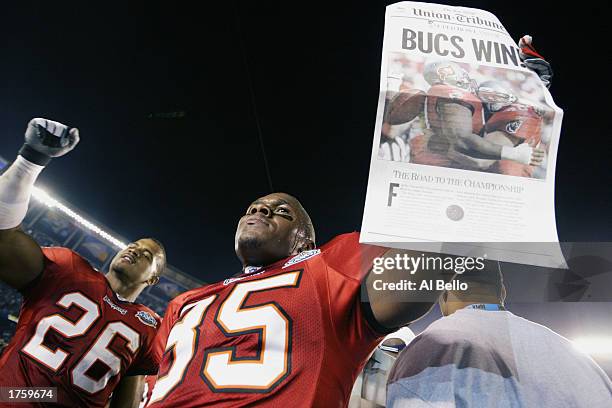 Cornerback Dwight Smith of the Tampa Bay Buccaneers celebrates as teammate Corey Ivy holds a newspaper proclaiming that his team defeated the Oakland...