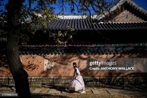 People wear traditional Hanbok dresses as they visit the Gyeongbokgung Palace grounds in Seoul on November 2, 2023. Built in 1395, the Gyeongbokgung...