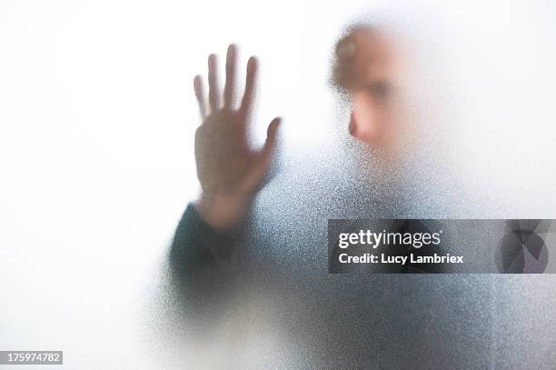 emerging man behind glass - translucent glass stock pictures, royalty-free photos & images