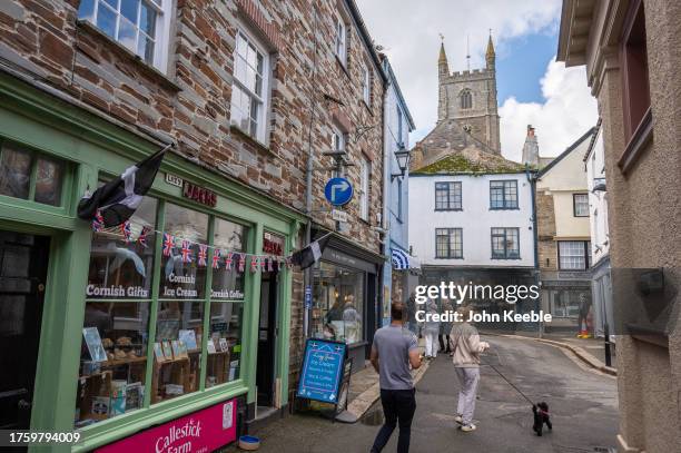 People walk along the street past a Cornish Gift Shop selling Ice Cream, Coffee, confectionary and gifts on September 22, 2023 in Fowey, Cornwall,...