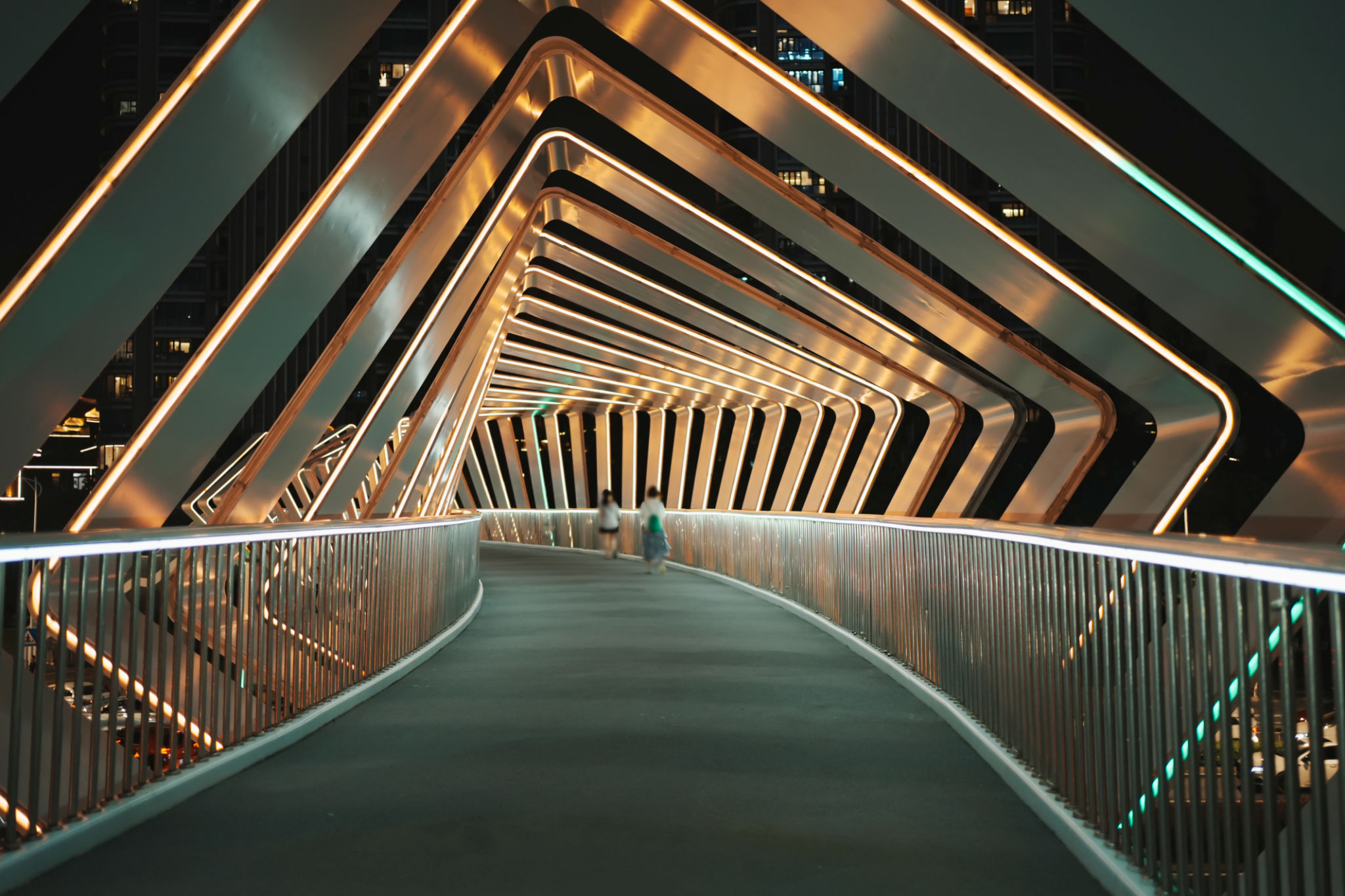 Pedestrians walk on a modern pedestrian bridge Pedestrians walk on a modern pedestrian bridge