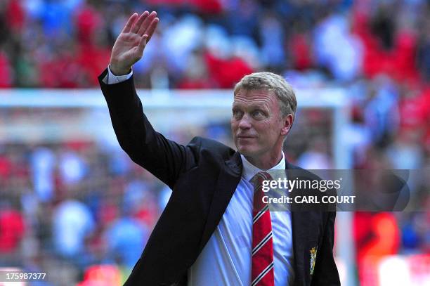 Manchester United's Scottish manager David Moyes waves as Manchester United celebrate after beating Wigan Athletic the FA Community Shield football...