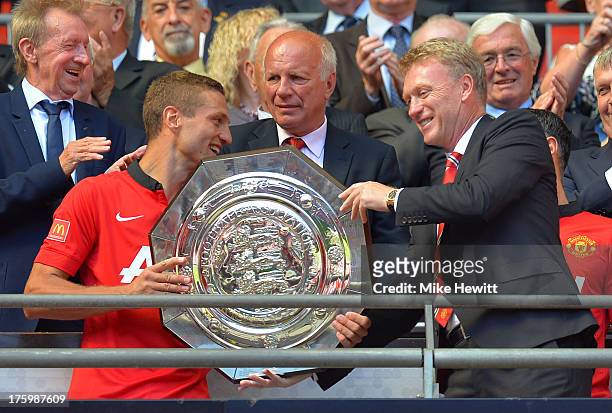 Nemanja Vidic of Manchester United and manager David Moyes with the trophy after victory in the FA Community Shield match between Manchester United...