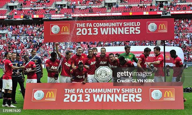 Manchester United players celebrate with the trophy after beating Wigan Athletic to win the FA Community Shield football match between Manchester...