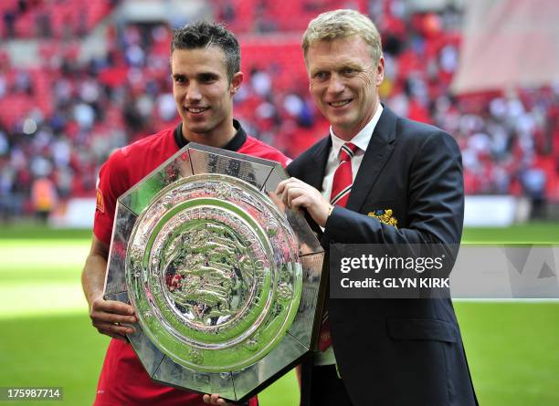 Manchester United's Dutch striker Robin Van Persie and Scottish manager David Moyes celebrate with the trophy after beating Wigan Athletic to win the...