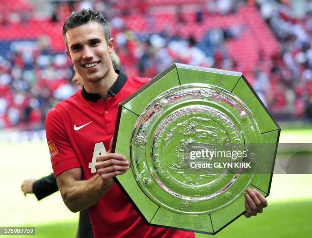 Manchester United's Dutch striker Robin Van Persie celebrates with the trophy after beating Wigan Athletic to win the FA Community Shield football...