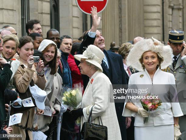 French President Jacques Chirac waves as he walks with First Lady Bernadette Chirac and Queen Elizabeth II from the Elysee Palace to the British...