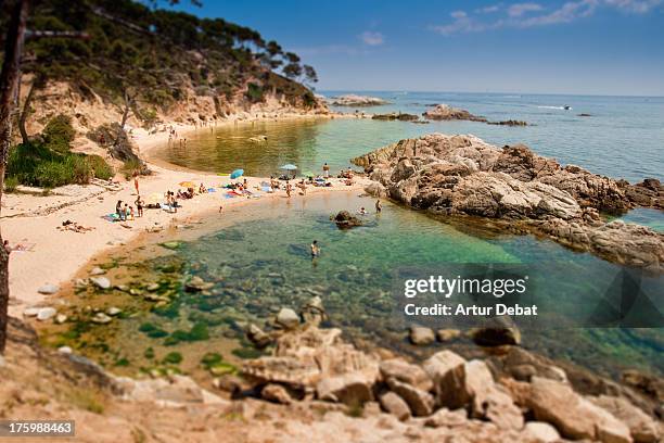 costa brava green water beach with people. - barcelona province stock pictures, royalty-free photos & images