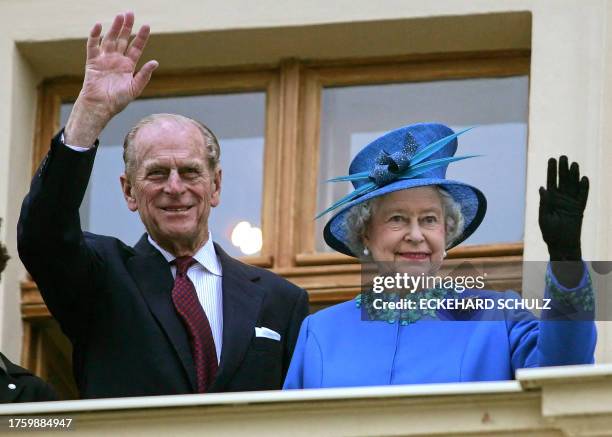 Britain's Queen Elizabeth II and her husband Prince Philip, Duke of Edinburgh, wave from the balcony of the former Prussian estate Krongut Bornstedt...