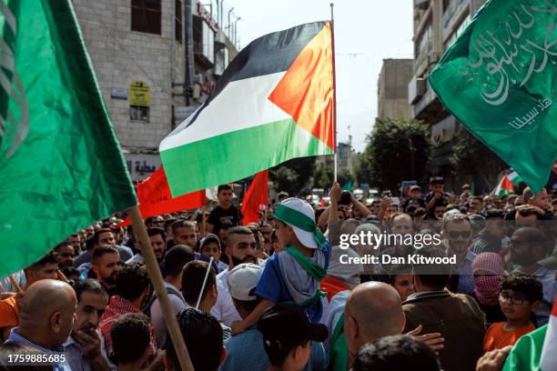 Boy wearing a Hamas headband holds a Palestinian flag as protesters gather for a demonstration in support of the Palestinian people on October 27,...