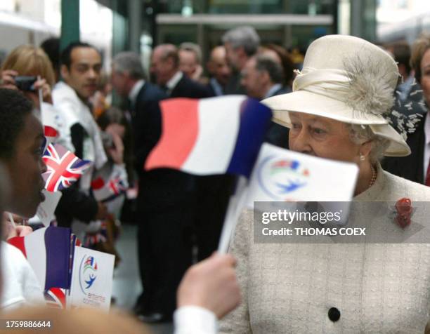 School children wave French flags as Queen Elizabeth II arrives at the Gare du Nord train station in Paris, 05 April 2004, for the start of a...