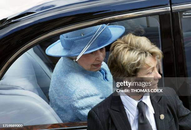 An unidentified female bodyguard stands by as Queen Elizabeth II leaves after visiting the pedestrian Rue Montorgueil in Paris 06 April 2004, on the...