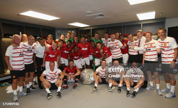 The Manchester United squad and coaching staff celebrate with the FA Community Shield trophy in the dressing room after the FA Community Shield match...