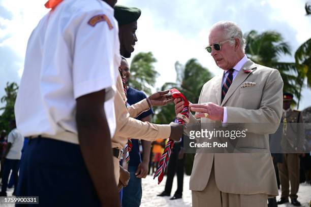 Britain's King Charles III receives a neckerchief and a badge from Kenyan Scouts during a visit to Nyali beach on November 2, 2023 in Mombasa, Kenya....