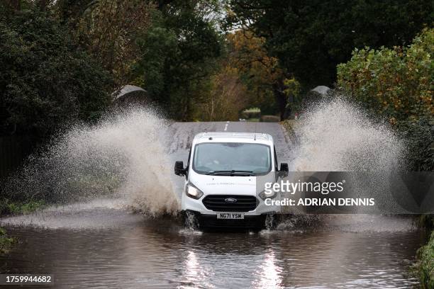 Car drives along a flooded road in Romsey, southern England, on November 2, 2023 as strong winds and heavy rain from Storm Ciaran hit Britain. High...