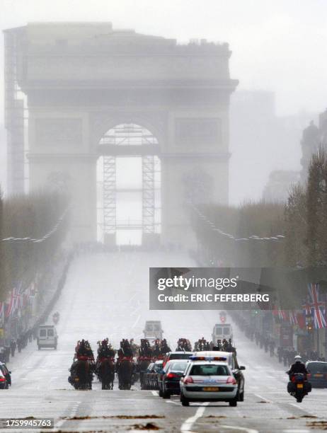 Queen Elizabeth II and her husband Prince Philip ride in a convoy escorted by 150 horse-mounted Republican Guards as they drive towards the Arc de...