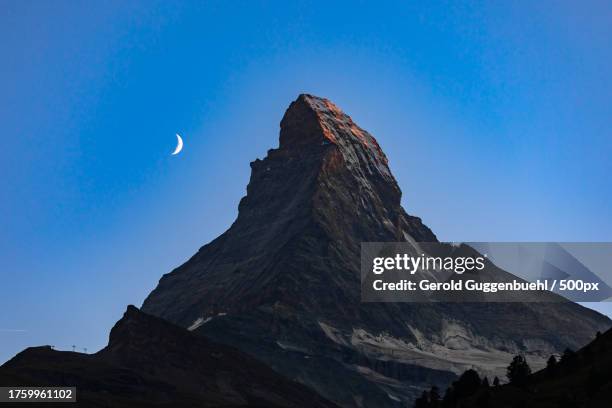 low angle view of rock formation against clear blue sky - gerold guggenbuehl fotografías e imágenes de stock