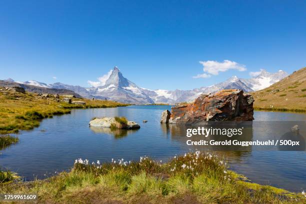 scenic view of lake and mountains against blue sky - gerold guggenbuehl stock pictures, royalty-free photos & images