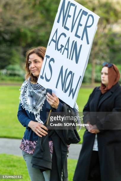 Protester holds a placard reading "never again is now" during a rally in Melbourne. In a heartfelt gathering in Melbourne Australia , Jews and their...