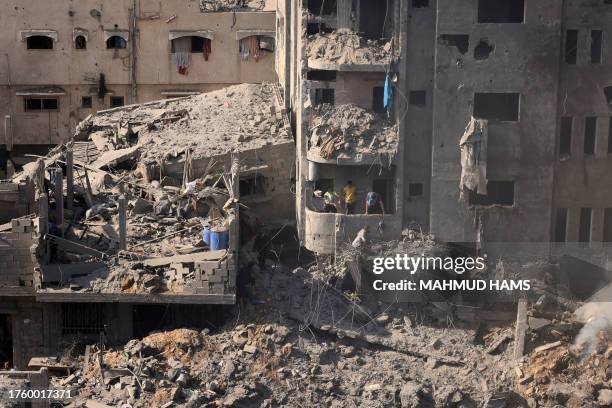 People check buildings destroyed in an Israeli strike on the Bureij refugee camp in the central Gaza Strip on November 2 as battles between Israel...