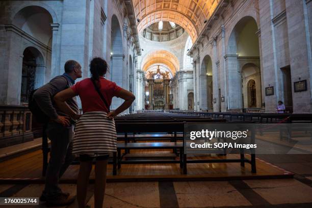 Two people are seen looking at the altar in the church of São Vicente de Fora, located in the Graça neighborhood. Graca is a district in Lisbon,...