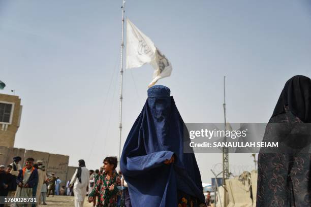 In this photo taken on November 1 an Afghan burqa-clad woman refugee walks near a registration centre upon her arrival from Pakistan, at the...