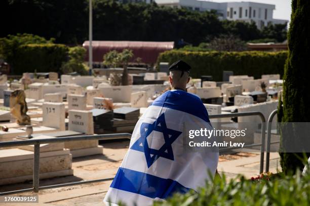 Soldier walks with an Israeli flag at the funeral of fallen Israeli soldier, Lior Siminovich, killed in a ground opreation in the Gaza Strip on...