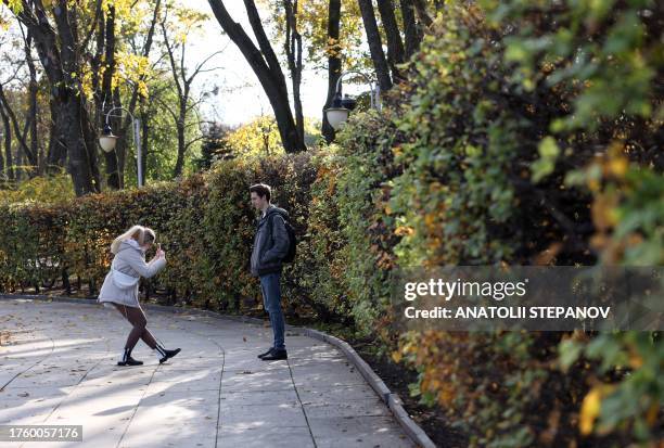 Couple takes pictures in a park in the Ukrainian capital city of Kyiv on October 2, 2023.