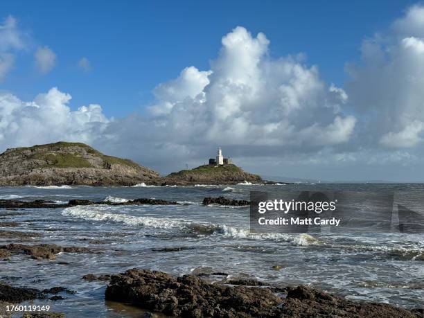 Waves break in front of Mumbles Lighthouse viewed from Bracelet Bay on October 27, 2023 in Swansea, Wales. The city of Swansea and the nearby Gower...