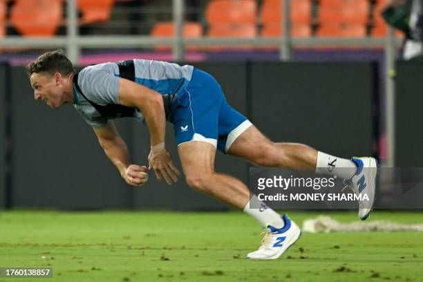 England's captain Jos Buttler dives to catch the ball during a practice session ahead of their 2023 ICC Men's Cricket World Cup one-day international...