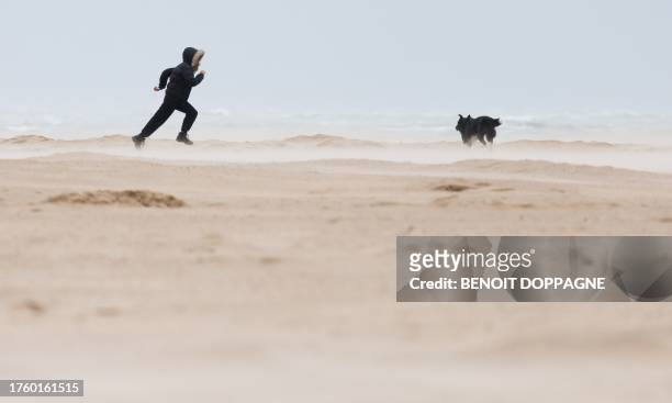 Chlid and a dog run on beach ahead of the storm Ciaran expected to hit the region, in Ostend, on November 2, 2023. Storm Ciaran battered northern...