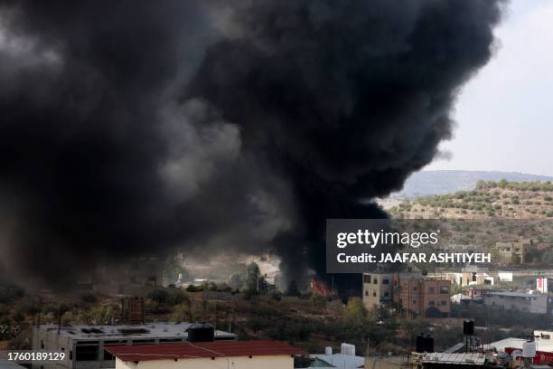 Black smoke fills the air in the Palestinian village of Dayr Sharaf, in the West Bank located about seven kilometres from the Jewish Einav settlement...