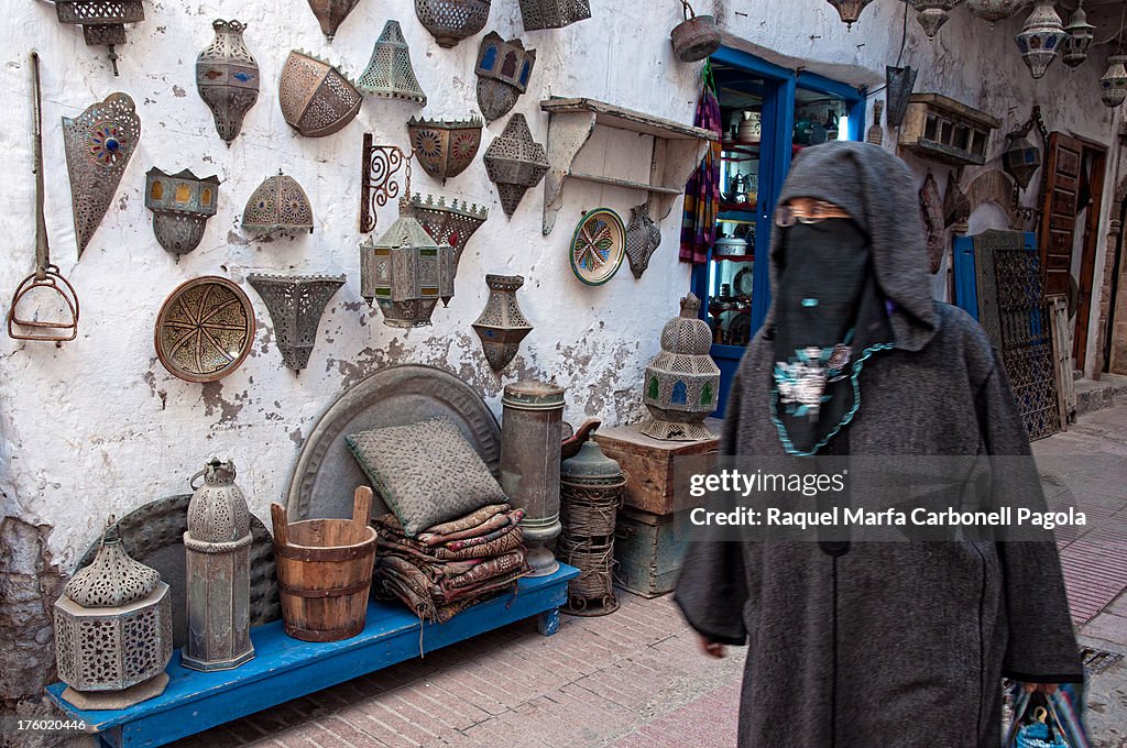 Woman passing by a lamps shop, Essaouira, Morocco