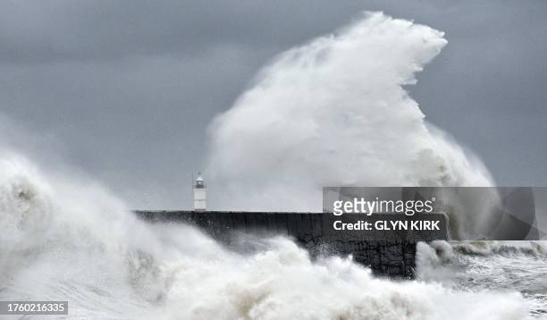 Waves crash over Newhaven Lighthouse and the harbour wall in Newhaven, southern England on November 2 as strong winds and heavy rain from Storm...