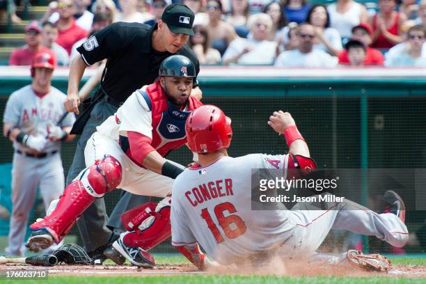 Home plate umpire Vic Carapazza watches as catcher Carlos Santana of the Cleveland Indians tags out Hank Conger of the Los Angeles Angels of Anaheim...
