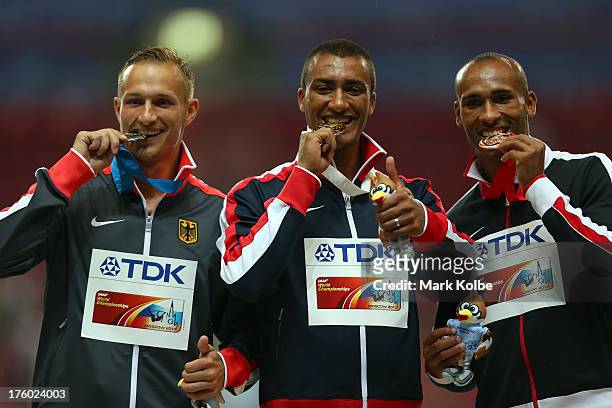 Silver medalist Michael Schrader of Germany, gold medalist Ashton Eaton of United States and bronze medalist Damian Warner of Canada stand on the...