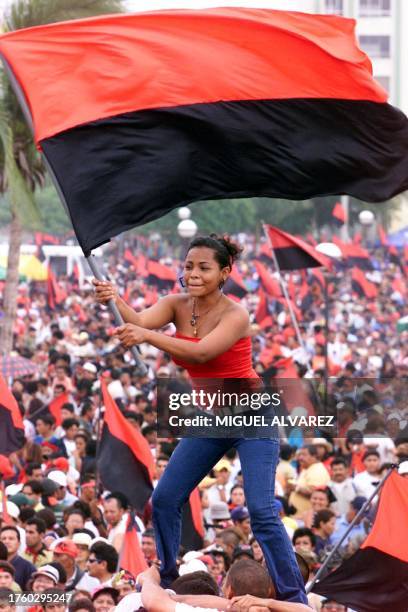 Una simpatizante del Frente Sandinista de Liberacion Nacional agita una bandera subida sobre un grupo de jovenes, el 19 de julio del 2004, en...