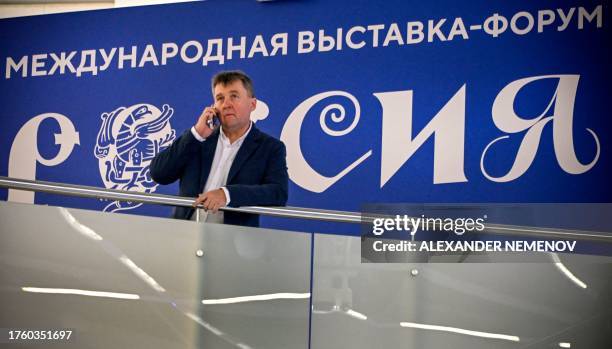Man speaks on the phone next to the logotypes of Russia Expo exhibition, designed to demonstrate Russia's main achievements in culture and technology...