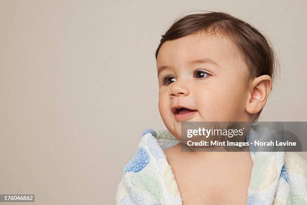 an 8 month old baby boy with a bath towel wrapped around him. - baby bath stock-fotos und bilder