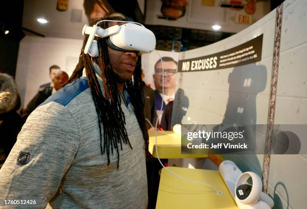 Alumni Georges Laraque looks at the virtual reality in the United by Hockey Mobile Museum after the Legacy Project press conference ahead of the 2023...